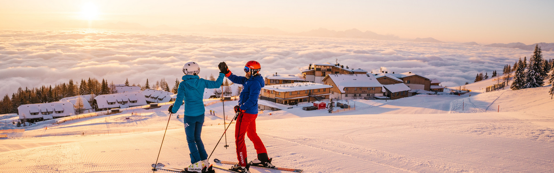 Skifahrer auf der Gerlitzen Alpe über dem direkt an der Piste gelegenen Skihotel Feuerberg in Kärnten