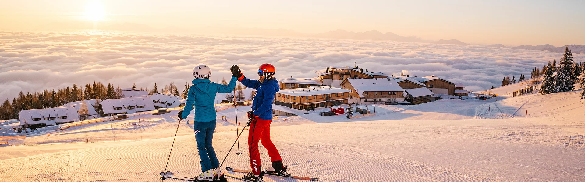 Skifahrer auf der Gerlitzen Alpe über dem direkt an der Piste gelegenen Skihotel Feuerberg in Kärnten