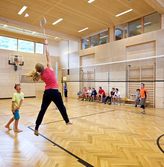 Kinder und Teenager spielen Volleyball in der Indoor Kletterhalle bzw. Sporthalle des Mountain Resort Feuerberg im Bergurlaub in Kärnten