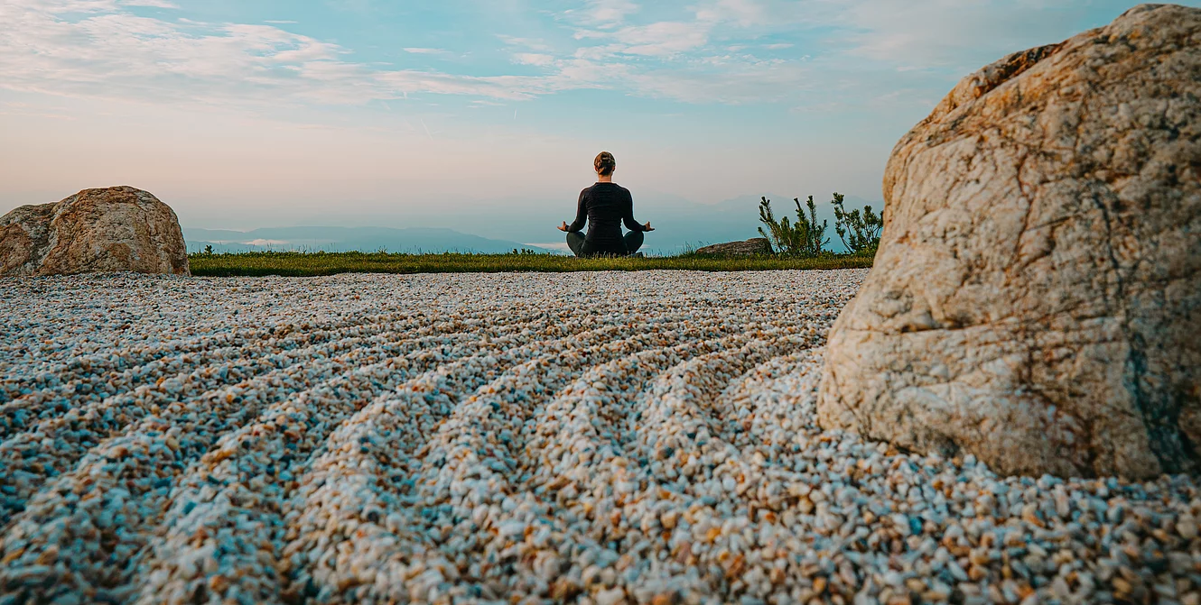 Inclusive services Eine Person in Meditationsposition mit Blick auf die Weite