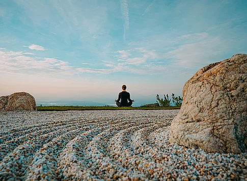 Eine Person in Meditationsposition mit Blick auf die Weite
