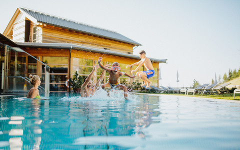 Familie schwimmt im Sommer in der Alpentherme im Family Spa und Wellnesshotel Feuerberg in Kärnten