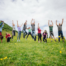 Das Gastgeber Team des Mountain Resort Feuerberg läuft über eine Wiese auf der Gerlitzen in Kärnten