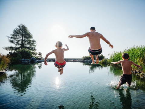 Kinder springen im Sommer in den Almsee des Family Spa Wellnesshotel Feuerberg in Kärnten