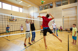 KInder und Teenager beim Volleyball Spielen in der Turnhalle im Familienhotel Feuerberg in Kärnten