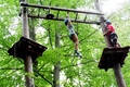 Teenager und Mann auf einem Hochseilgarten im Wald im Urlaub in Kärnten