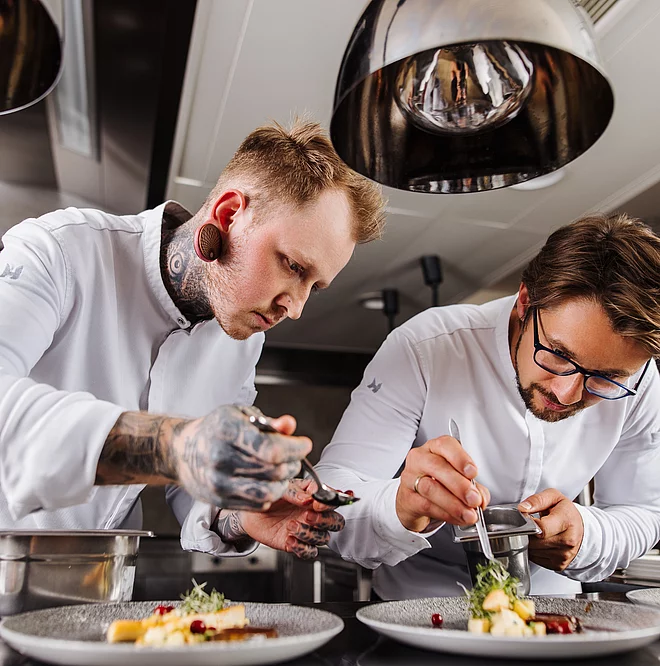 Küchenteam beim Anrichten von exquisiten Speisen