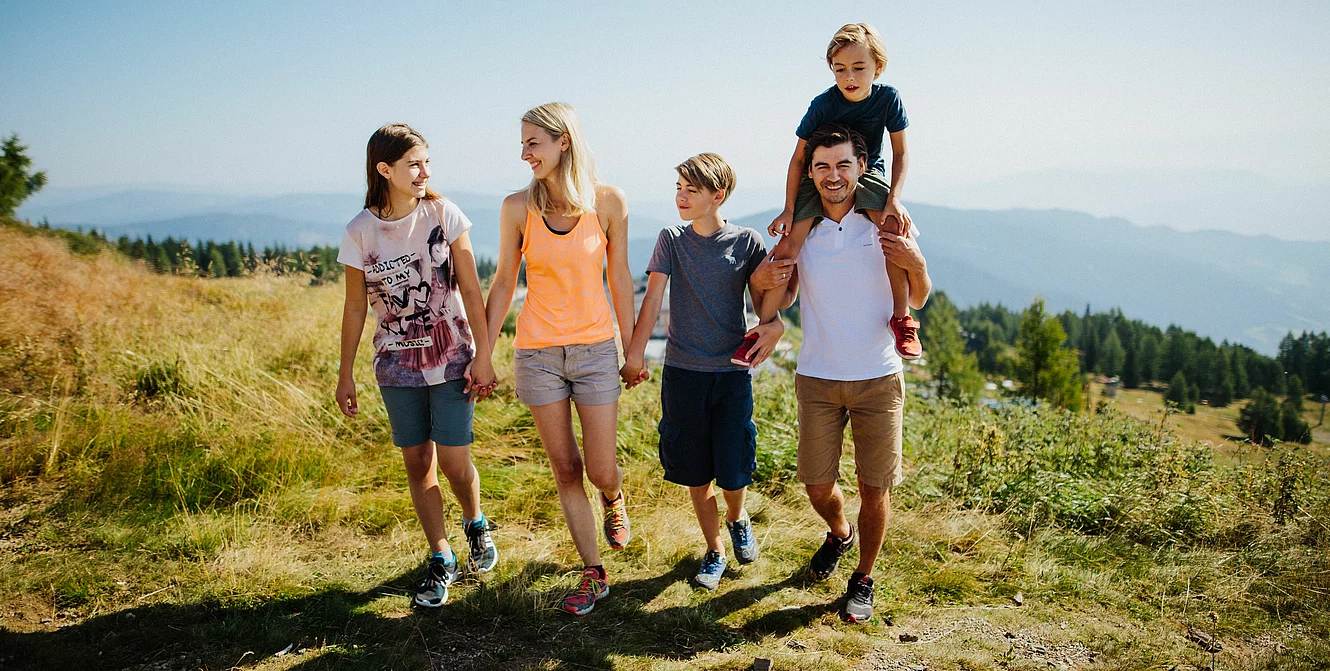 Erlebnisberg Gerlitze Familie beim Wandern auf der Gerlitzen im Sonnenschein im Familienurlaub in Kärnten