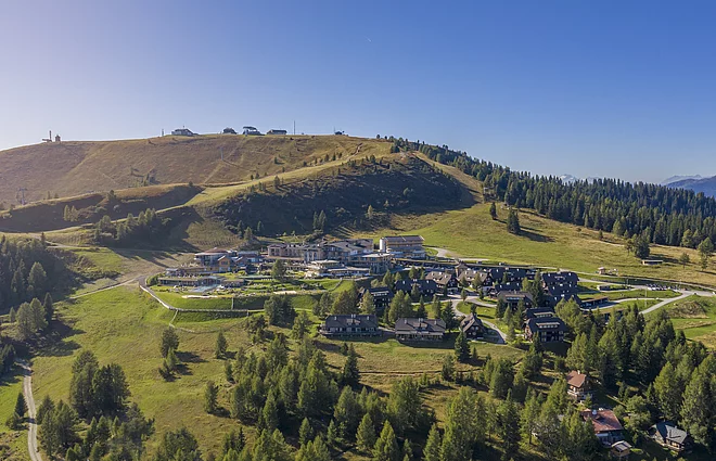Drohnenaufnahme des Mountain Resort umgeben von blühender Alm