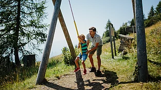 Vater schubst Sohn beim Flying Fox im Urlaub mit der ganzen Familie in Kärnten
