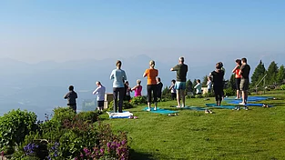 Eine Gruppe von Menschen macht Yoga im freien am Feuerberg
