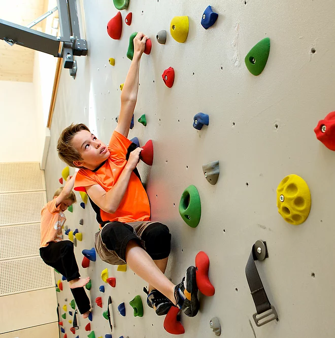 Kinder klettern in der Kletterhalle des Mountain Resort Feuerberg im Bergurlaub in Kärnten