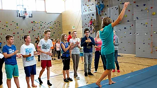 Mädchen auf Slackline in der Turnhalle im Familienurlaub mit Teenager in Kärnten