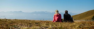 Mann und Frau beim Rasten nach einer Wanderung im Urlaub nahe des Mountain Resort Feuerberg in Kärnten