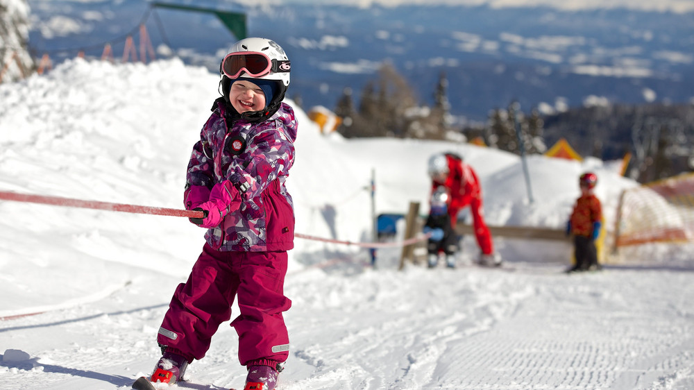 Kinder beim Skikurs an einem Schnurlift des Hotel Mountain Resort Feuerberg direkt an der Piste im Skiurlaub in Kärnten